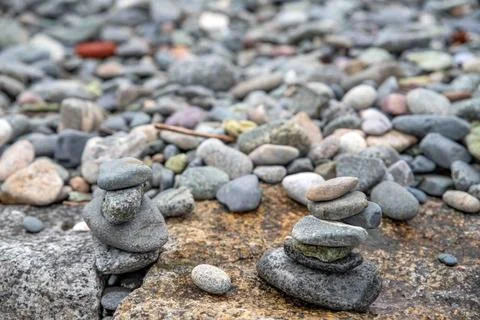 Smooth stacked gray pebbles on a tranquil Massachusets shoreline Closeup h... Stock Photos