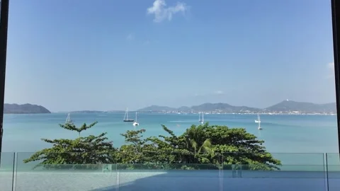 Smooth steadicam shot of hotel window overlooking paradise beach Stock Footage 302763250