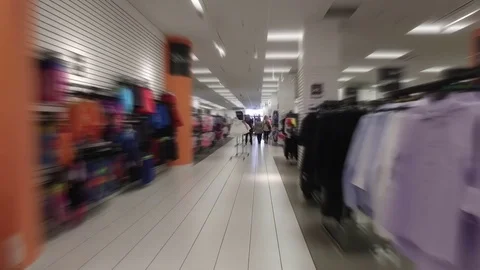 Smooth &amp; steady slow motion blurred walk-through shopping mall clothing store Stock Footage 71999398