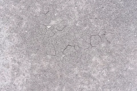 Smooth surface of grey ground with cracks during drought as background Stock Photos