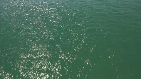 Smooth tracking drone shot over sun glistened sea. 스톡 동영상 150406615
