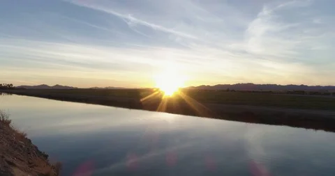 Smooth tracking shot with still river and stunning sunset drone aerial 4K Stock Footage 111310086