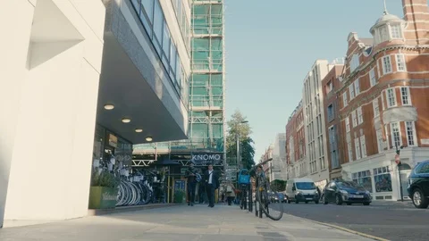 Smooth tracking shot, walking along a central London road with blue sky Stock Footage 88956016