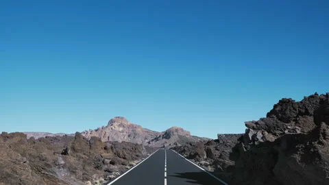 Smooth traffic on the road through the dead desert of black lava volcano Teide Video stock 100429780
