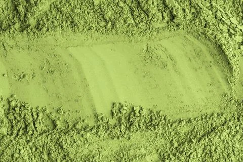 Smooth trail divides vibrant matcha green powder, highlighting contrast betwe Stock Photos
