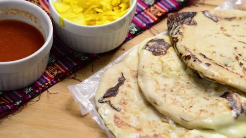 A smooth video pan showcasing cheese-filled pupusas with curtido and sauce .. 動画素材 294112896