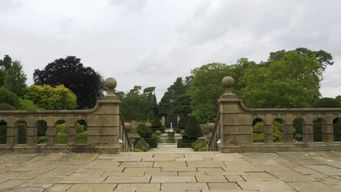 Smooth walking motion into pretty gardens toward water feature, drone aerial 4K Stock Footage 101129042