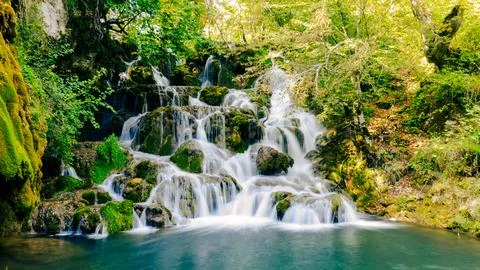 Smooth water effect capturing motion of clean mountain waterfall in forest Stock Photos