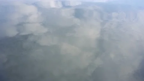 Smooth water surface with clouds reflected in it Stock Footage 217952078
