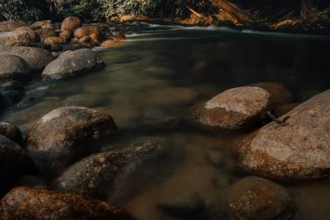 Smooth waterfall on dark-colored rocks Stock Photos
