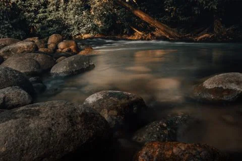 Smooth waterfall on dark-colored rocks Stock Photos