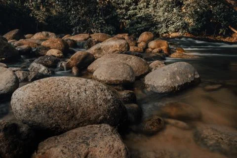 Smooth waterfall on dark-colored rocks Stock Photos
