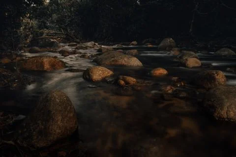 Smooth waterfall on dark-colored rocks Stock Photos
