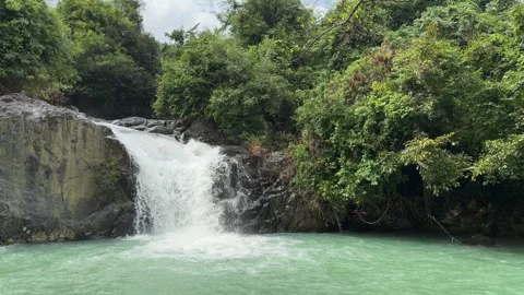 A smooth waterfall pours in slow motion into a small natural basin, water Stock Footage 324889737