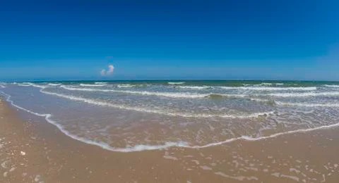 Smooth wave of sea on the beach with small cloud and blue sky Фото