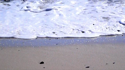 Smooth waves rolling onto the beach Stock Footage 87726898
