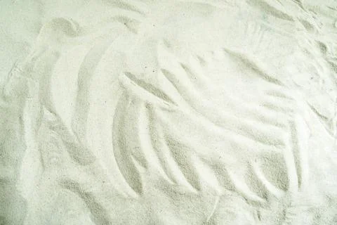 Smooth, wavy patterns carved in fine white sand, creating a minimalist text.. Stock Photos