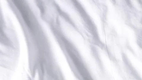 Smooth white fabric texture with soft folds and natural light reflections Stock Photos