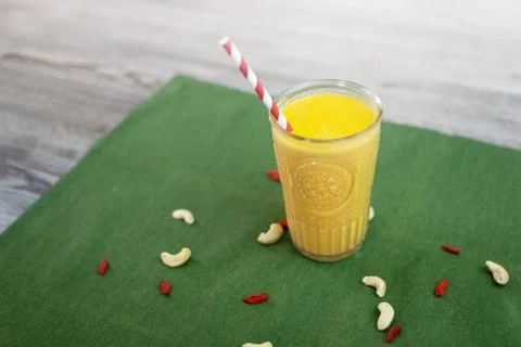 Smoothie made of cashew and goji berries with an eco paper tube. Stock Photos