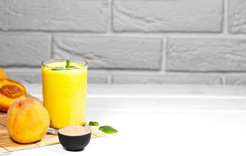 Smoothie with peach and mint leaf with piece of cloth on white background Stock Photos