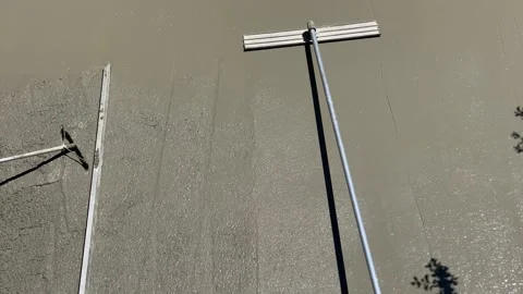 Smoothing freshly poured concrete using long-handled bull float Vídeos de archivo 134075232