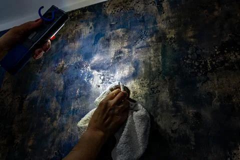 Smoothing out wallpaper irregularities with the light of a flashlight, Stock Photos