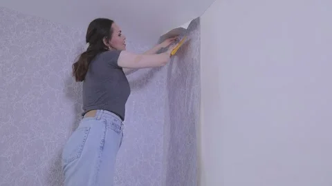 Smoothing wallpaper onto the wall to remove air bubbles. Stock Footage 331959388