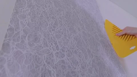 Smoothing wallpaper onto the wall to remove air bubbles. Video stock 332019085
