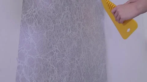 Smoothing wallpaper onto the wall to remove air bubbles. Vídeo Stock 332368887