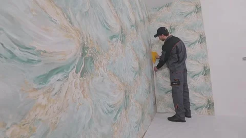 Smoothing wallpaper onto the wall to remove air bubbles. Stock-Footage 335619894