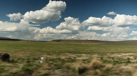Smoothly passing puffy clouds and green countryside Stock Footage 61687912