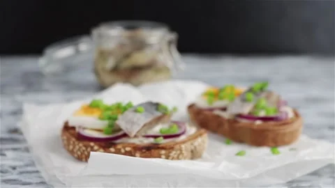 Smorrebrod  open sandwich with rye bread herring boiling egg  green onions Stock Footage 106874079