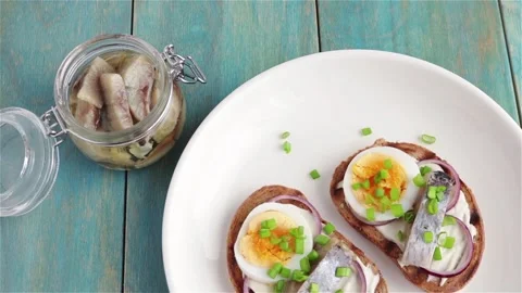 Smorrebrod  open sandwich with rye bread herring boiling egg  green onions Stock Footage 107385826