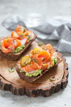 Smorrebrod with salmon on rye bread with vegetables and herbs Stock Photos
