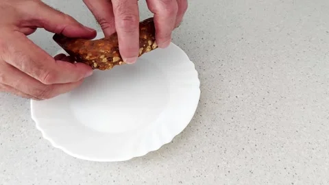 Snack Bar Snap. Hands Tear Into a Dense, Nutty Treat on White Plate Vídeos de archivo 316581510