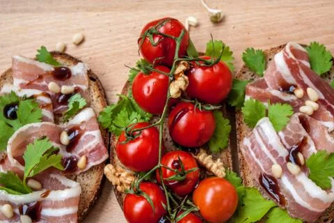 Snack of bread (baguette), bacon (ham), tomatoes, balsamic and spices. Stock-Fotos