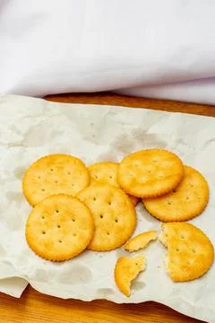 Snack concept, Crackers or biscuit stack in parchment paper with cracker scra Stock Photos