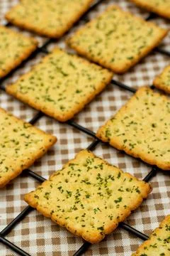 Snack concept, Vegetable crackers or biscuits in black pastry rack on gingham 스톡 사진