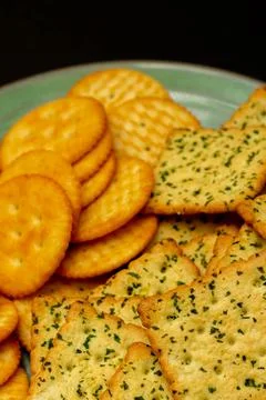 Snack concept, Vegetable crackers or salty biscuits in a plate isolated on bl Stock Photos