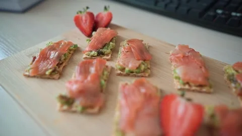 Snack items are arranged neatly on a wooden board, featuring thin slices of Stock Footage 339005056