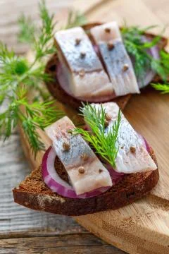 Snack of rye bread, red onion, herring and dill. Stock Photos