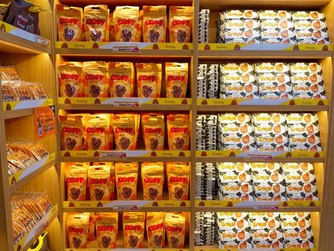 Snack Stack: Colorful Packaged Goods on Wooden Shelves Stock Photos