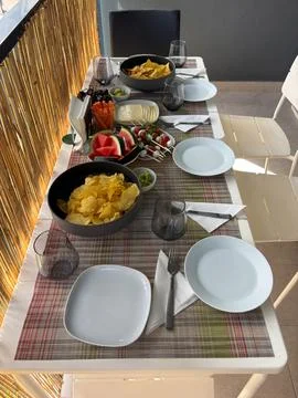 Snack table set on a cozy balcony with chips and appetizers Stock Photos