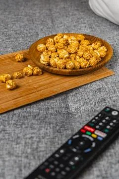 Snack time with popcorn and remote control on a couch Stock Photos