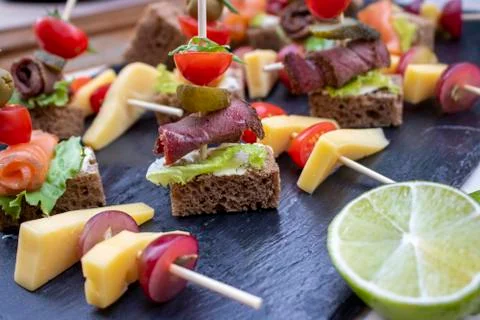 Snacks cheese and lime with brown bread on the kitchen board Stock Photos