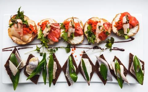 Snacks with fish and vegetables. The set of cheese.Tapas with red fish and sh Stock Photos