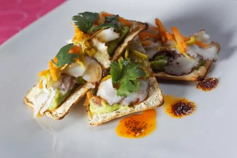 Snacks of fish fillets in mango sauce with strips of pepper served on cracker Foto stock