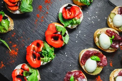 Snacks with meat and vegetables. Tapas with salmon and pickled cucumber. Pr.. Stock Photos