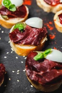 Snacks with meat and vegetables. Tapas with salmon and pickled cucumber. Pros Stock Photos