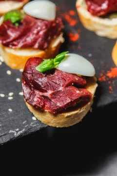 Snacks with meat and vegetables. Tapas with salmon and pickled cucumber. Pros Stock Photos